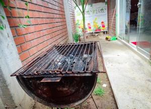 Una parrilla situada junto a un edificio de ladrillos. en Casita Tingo María, en Tingo María
