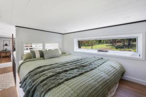 a bedroom with a large bed and a window at Big Tiny Medlow in Medlow Bath