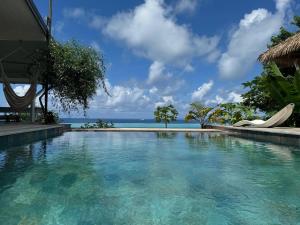 a swimming pool with a view of the ocean at Fare Mãhanahana in Taoru