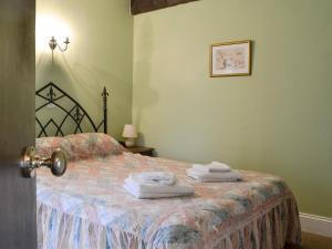 East DownにあるWheelwrightsのタオルが敷かれたベッドのある寝室