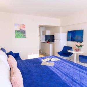 1 dormitorio con 1 cama azul, mesa y sillas en Orbi City Batumi official Seafront, en Batumi