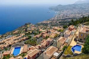 an aerial view of a town next to the water at Balancal Apartments and Villas Palheiro Village in Funchal