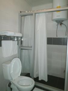 a bathroom with a white toilet and a shower at Hotel H1 in Toamasina