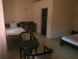 een kamer met een bed en een tafel en stoelen bij Hotel H1 in Toamasina