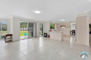 Il comprend une grande cuisine et un salon aux murs blancs. dans l'établissement Aircabin - Wyong Creek - Cozy Country Home, à Yarramalong