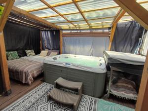 a room with a bed and a tub in a tent at Appartement entier, jacuzzi et parc in Orange
