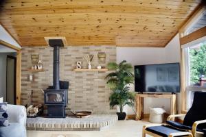 a living room with a brick fireplace and a tv at Serendipity 5 BR Waterfront 4 Seasons, Hot Tub, Firepit, Close to Ski HIll in Haliburton