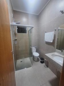 a bathroom with a shower and a toilet and a sink at Regente Feijó Centro in Regente Feijó
