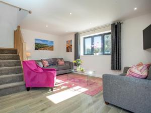 a living room with a couch and a pink chair at Brook Cottage-Uk44378 in Washford