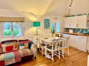 a kitchen and living room with a table and chairs at Chapel Barn in Bodmin +10 photos