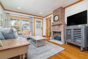 a living room with a fireplace and a flat screen tv at Remodeled 1920s Charmer Near ETSU, JCMC & Downtown in Johnson City