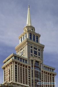 ein hohes Gebäude mit einem Turm darüber in der Unterkunft Triumph Palace Boutique Hotel in Moskau