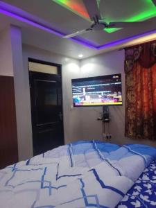 a bedroom with a bed and a flat screen tv at The Nobles Luxurious 2 Bedroom Apartment in Kumasi