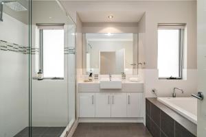 een badkamer met een wastafel en een glazen douche bij Two-Storey Lakeview Retreat at Dunsborough Lakes in Dunsborough +24 foto's