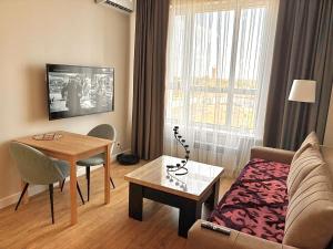 a small living room with a couch and a table at Yassaui Apartments in Astana