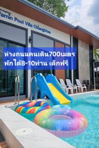 a swimming pool with a slide and an inflatable at Vamin Poolvilla Chiangkhan Loei วามินทร์พูลวิลล่า เชียงคาน เลย - วามินทร์ รีสอร์ท in Chiang Khan