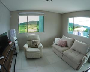 een woonkamer met een bank en een stoel bij Ecos da Serra in Bezerros