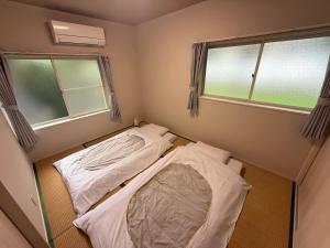 Postel nebo postele na pokoji v ubytování Satsuki Apartment Hotel - Koguchi Area