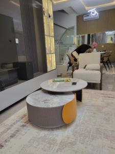 sala de estar con mesa, sofá y una persona en Adeniyi Jones Court Luxury Home, en Ibadán