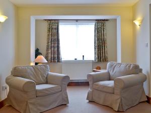 a living room with two chairs and a window at Garden Farm Cottage in Ilam