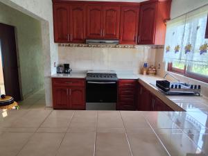 a kitchen with wooden cabinets and a stove top oven at Casa San Javier, La Loma in Tapalpa