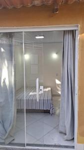 a room with a bed through a glass window at Casa Albatroz - primeira locaçao 4 suites in Búzios