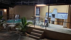 a large room with a pool and tables and chairs at Casa Albatroz - primeira locaçao 4 suites in Búzios