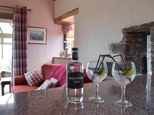 eine Flasche Wein mit zwei Gläsern auf einem Tisch in der Unterkunft Barns End Cottage in Ludchurch + 14 Fotos