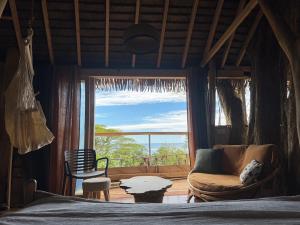 a bedroom with a bed and a couch and a window at Raiatea Treelodge in Taoru