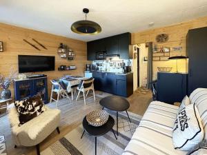 un salon avec un canapé et une table et une cuisine dans l'établissement Studio rénové avec balcon et parking aux Orres - FR-1-322-687, à Le Mélézet