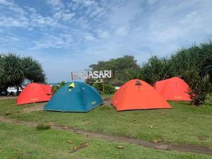 eine Gruppe von vier Zelten im Gras in der Unterkunft Sewa Tenda Pantai Madasari in Madasari