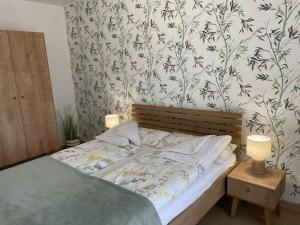 a bedroom with a bed with a floral wallpaper at One-bedroom apartment in Radzikowo