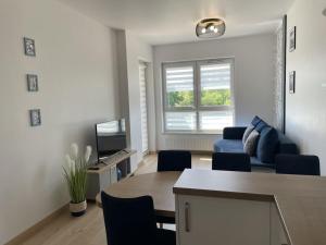 a living room with a blue couch and a tv at One-bedroom apartment in Radzikowo