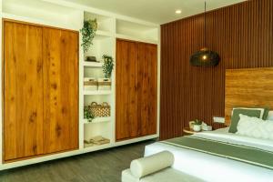 a bedroom with a bed and a wooden wall at Villa Samudra, Luxury and Comfort Villa by Balian Beach in Mantaak +18 photos