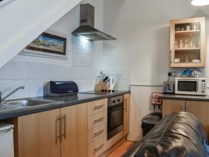 Una pequeña cocina con fregadero y microondas. en Jellicoe - Uk46102, en Ilfracombe