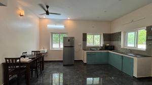 a kitchen with a refrigerator and a table and chairs at Villa19, ECR in Tirupporūr