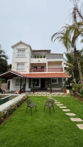 ein Haus mit zwei Stühlen im Hof in der Unterkunft Villa19, ECR in Tirupporūr