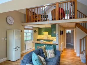 SaltonにあるLockwood Barnの青いソファと階段のあるリビングルーム