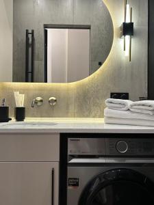 a bathroom with a washing machine and a mirror at Apart Complex Meridian из 10 отдельных апартаментов рядом с Арбатом in Almaty