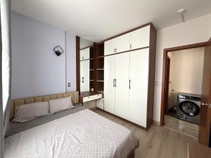 a bedroom with a bed and a washing machine at Sun House in Kinh Dinh