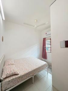 a bedroom with a bed in a white room at Home-Away Homestay in Gerik