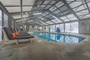 a large swimming pool with chairs in a building at Sun & Ski Inn and Suites in Stowe