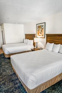two beds in a hotel room with white sheets at Crystal Inn Hotel & Suites - Salt Lake City in Salt Lake City +32 photos