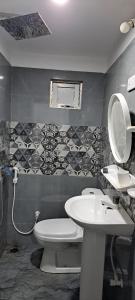 łazienka z białą toaletą i umywalką w obiekcie Shara HomeStay w mieście Trikunamalaja
