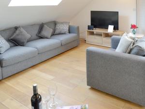 a living room with a couch and a tv at Lyndhurst in Perranporth