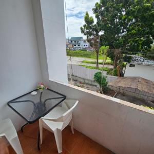 une table et des chaises en verre sur un balcon avec une fenêtre dans l'établissement Secrets - Pattaya, à Pattaya 22 autres photos