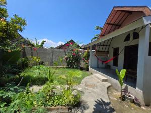 a garden in front of a house at Happy Village in Gili Islands