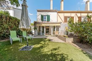 einen Regenschirm und Stühle im Hof eines Hauses in der Unterkunft Relax en la naturaleza a solo 45 min de Madrid in Collado Mediano