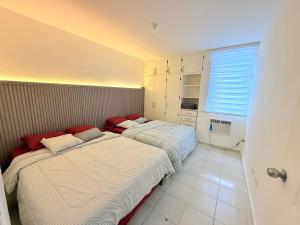two beds in a small room with a window at Hermoso apartamento en Calle 50 Panama in Panama City +19 photos