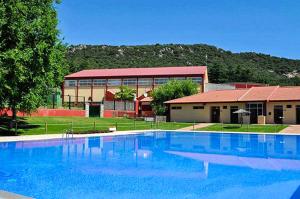 ein großer blauer Swimmingpool vor einem Gebäude in der Unterkunft Relax en la naturaleza a solo 45 min de Madrid in Collado Mediano